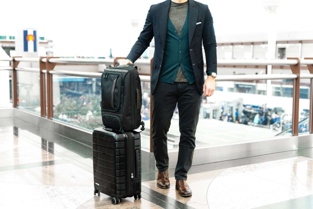 Man standing with two suitcases at the airport.