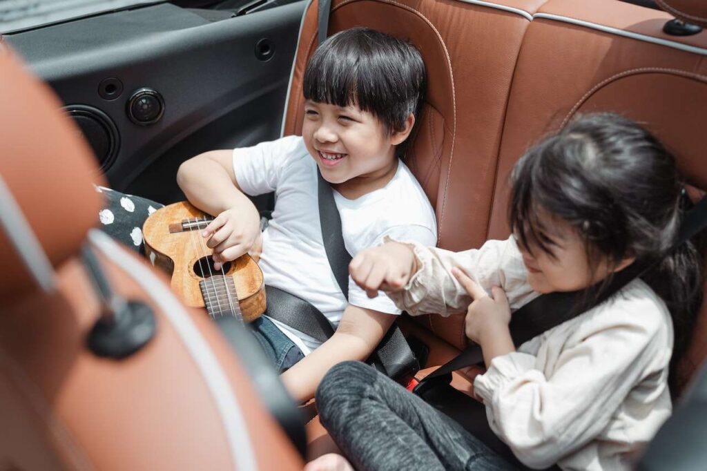 Two children sitting in the back seat of a sedan during a private airport transportation New York NY ride.