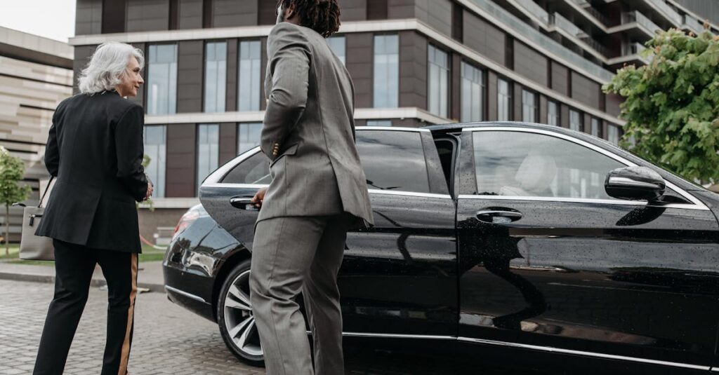 A chauffeur opening the rear door of a black sedan for a woman at a New York airport curb, private airport transportation New York NY.