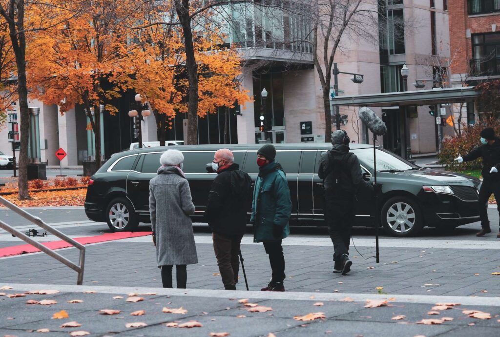 Travelers waiting on the street with bags before a JFK ride